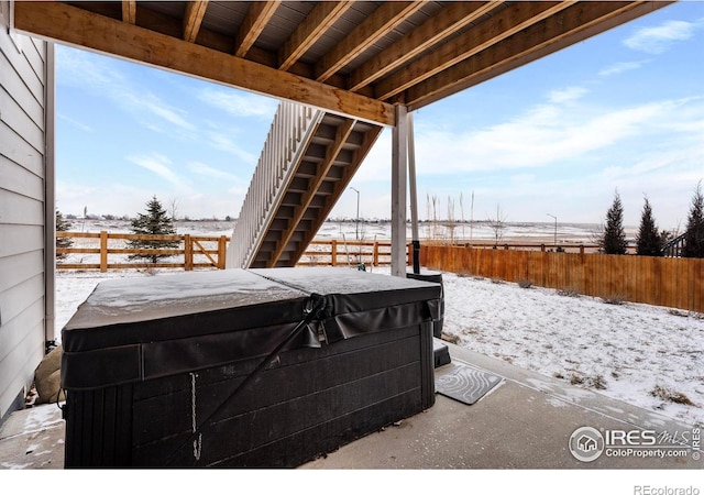 snow covered patio featuring a hot tub