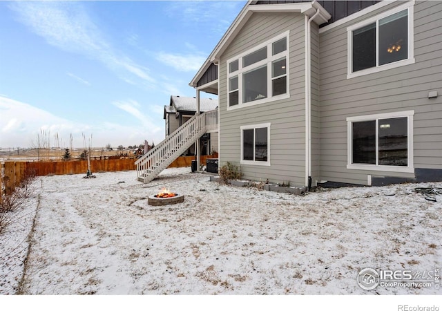 snow covered house featuring a fire pit