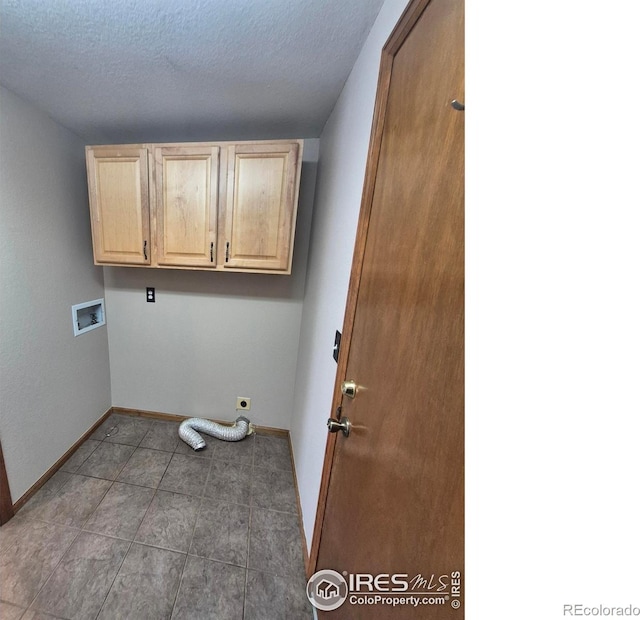 clothes washing area with cabinets, hookup for a washing machine, tile patterned flooring, and a textured ceiling