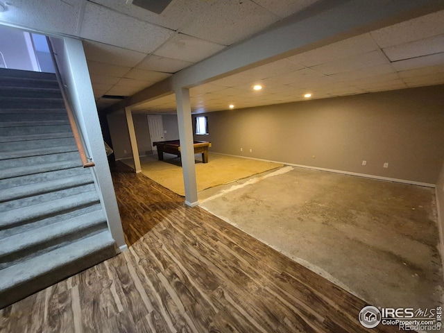 basement with a paneled ceiling, dark hardwood / wood-style flooring, and billiards