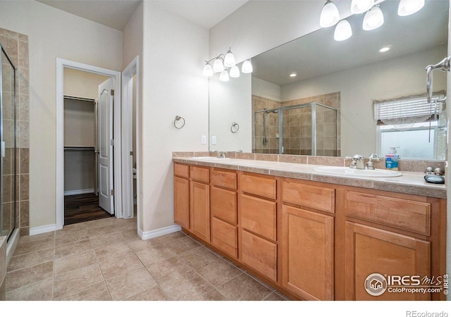 bathroom with a shower with door, vanity, and tile patterned flooring