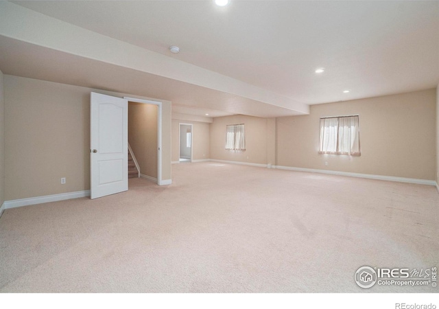 basement featuring a wealth of natural light and light colored carpet