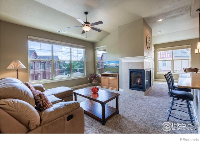 living room with light carpet, a wealth of natural light, a tile fireplace, and ceiling fan