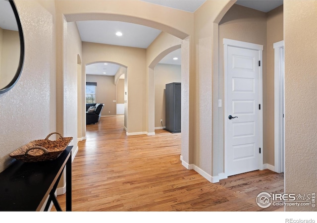 hallway with recessed lighting, baseboards, and light wood finished floors