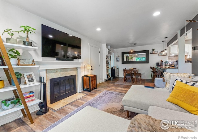 living room featuring wood-type flooring and a tile fireplace