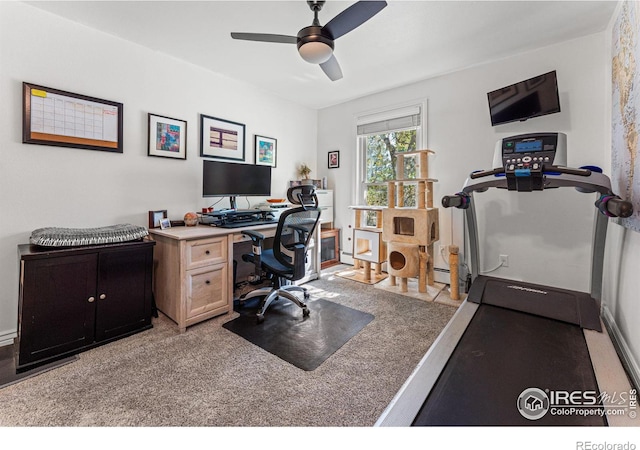 carpeted office with a baseboard heating unit and ceiling fan