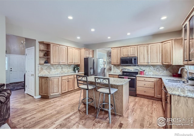133 Eagle Canyon Cir, Lyons, CO 80540 - kitchen with sink, light stone counters, a center island, light wood-type flooring, and appliances with stainless steel finishes