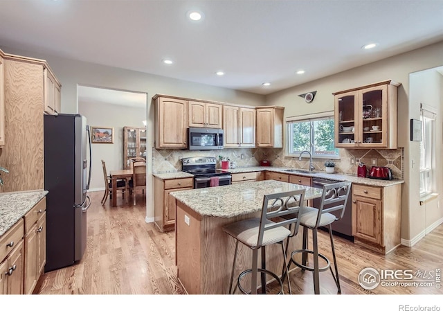 133 Eagle Canyon Cir, Lyons, CO 80540 - kitchen with sink, appliances with stainless steel finishes, a kitchen island, light stone countertops, and light hardwood / wood-style floors