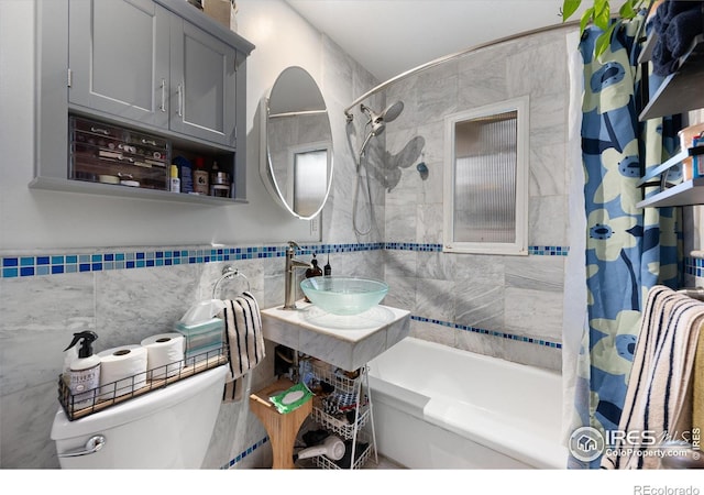 full bathroom with tile walls, sink, toilet, and shower / tub combo with curtain