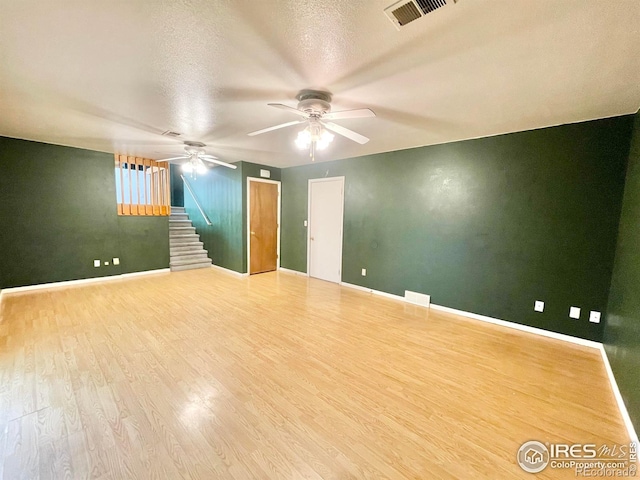 unfurnished room with ceiling fan, hardwood / wood-style floors, and a textured ceiling