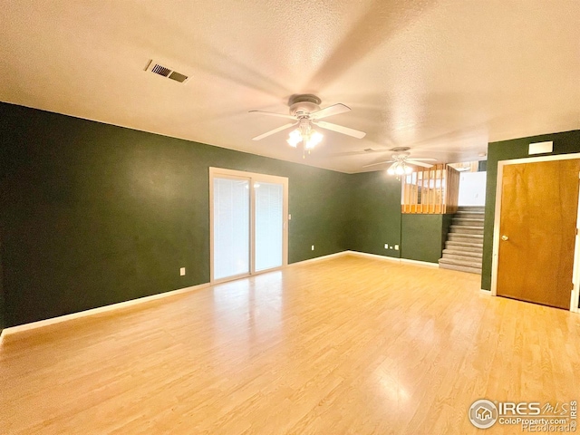 spare room featuring ceiling fan, light hardwood / wood-style flooring, and a textured ceiling