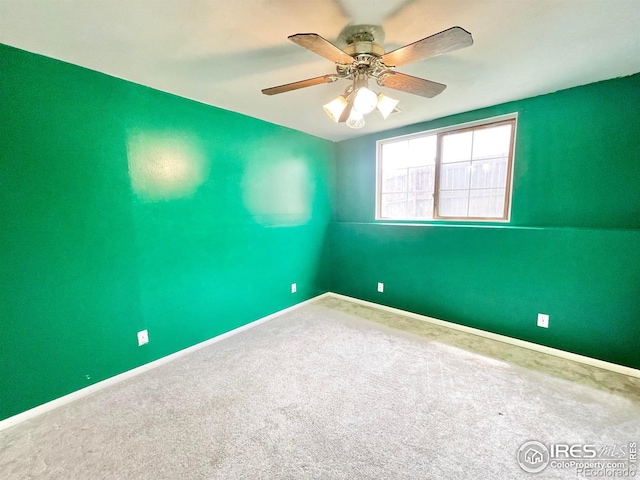 carpeted spare room featuring ceiling fan