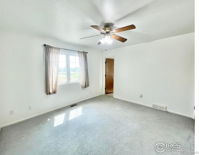 carpeted spare room with ceiling fan