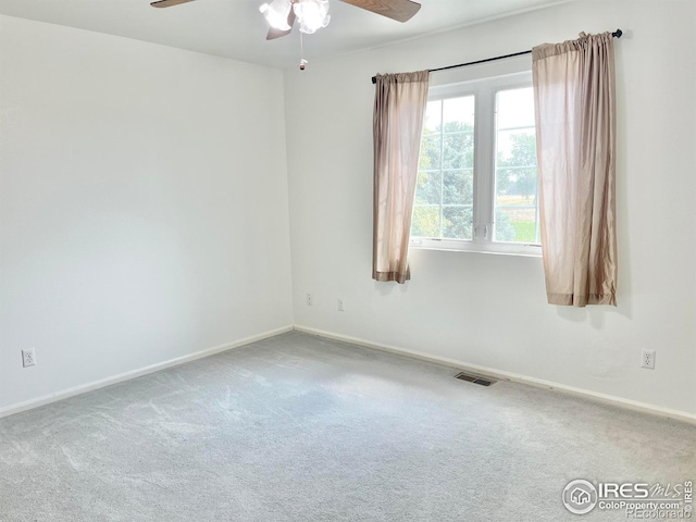 unfurnished room with ceiling fan and carpet