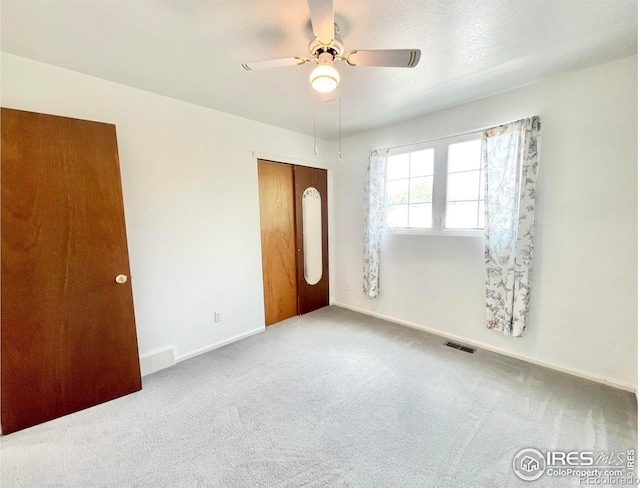 unfurnished bedroom featuring a closet, ceiling fan, and carpet flooring