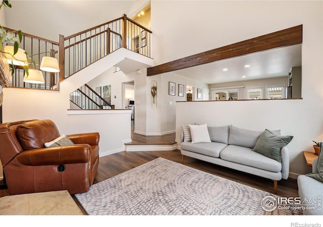 living room featuring a high ceiling and dark wood-type flooring