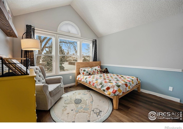 bedroom featuring lofted ceiling, dark wood-type flooring, and a textured ceiling