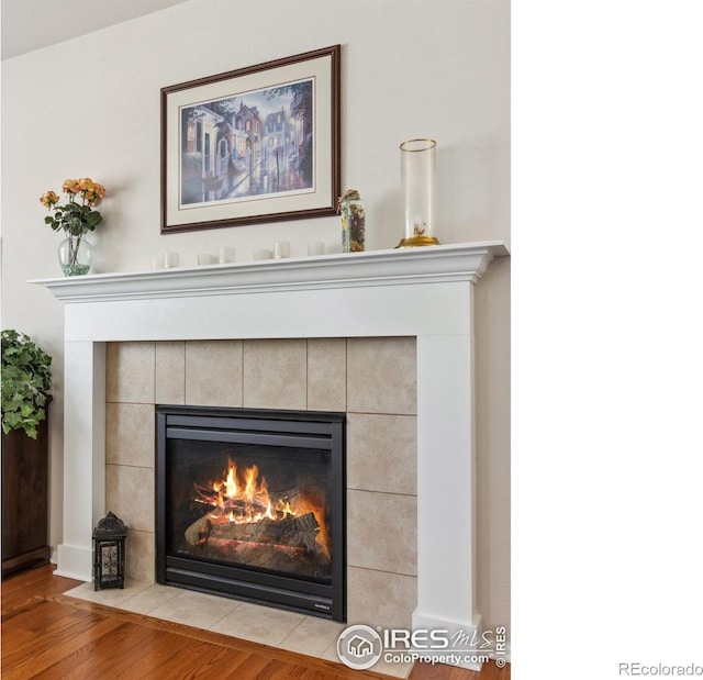 room details featuring a tiled fireplace and hardwood / wood-style floors