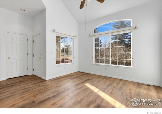 unfurnished dining area featuring ceiling fan, high vaulted ceiling, hardwood / wood-style floors, and a wealth of natural light