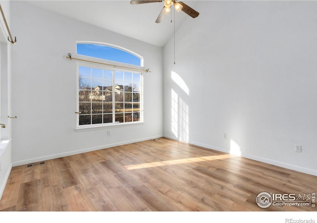 unfurnished room with hardwood / wood-style flooring, ceiling fan, and high vaulted ceiling