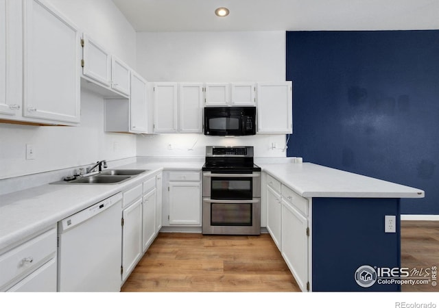 kitchen with white dishwasher, double oven range, white cabinetry, and sink