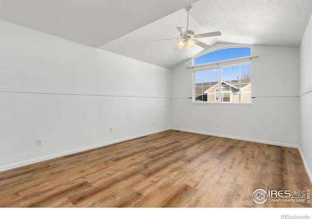 unfurnished room featuring lofted ceiling, a textured ceiling, wood-type flooring, and ceiling fan