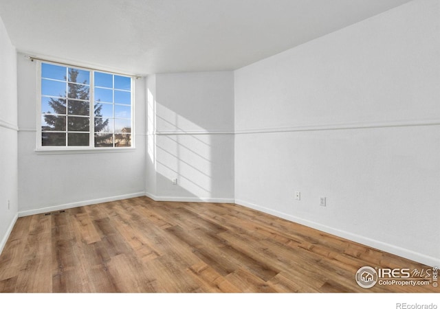 unfurnished room featuring hardwood / wood-style flooring