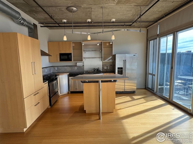 kitchen featuring a breakfast bar, appliances with stainless steel finishes, decorative light fixtures, and a center island