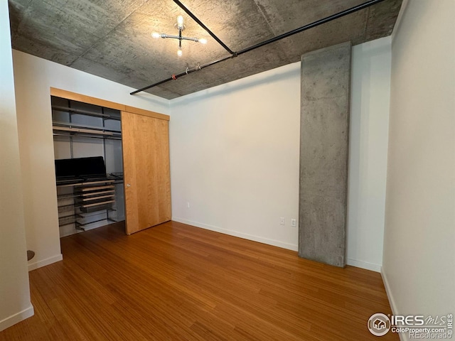 unfurnished bedroom with wood-type flooring and a closet