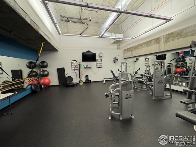 workout area featuring a towering ceiling