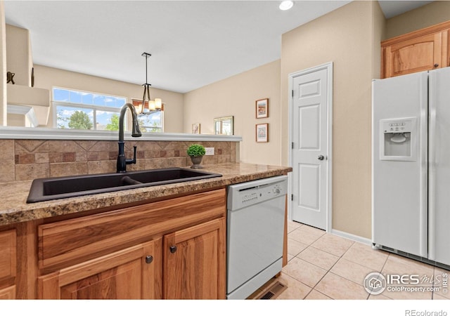 kitchen with decorative light fixtures, sink, light tile patterned floors, white appliances, and an inviting chandelier