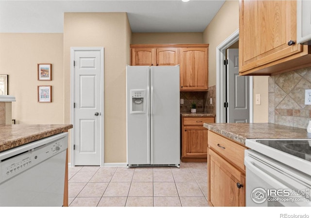 kitchen with tasteful backsplash, white appliances, light brown cabinetry, and light tile patterned floors