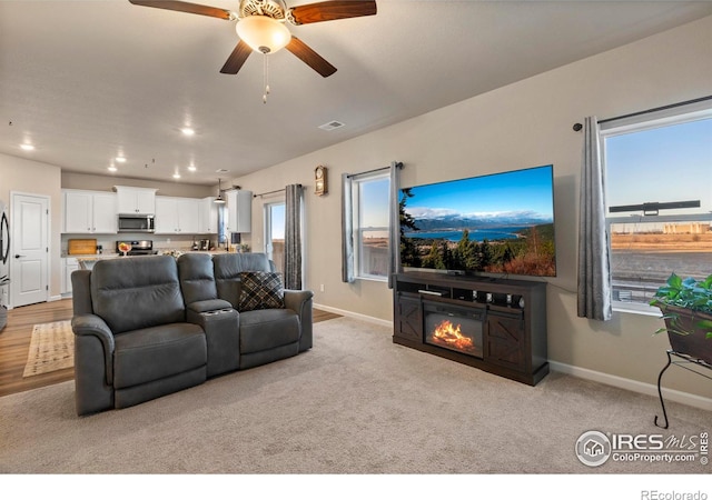 living room featuring ceiling fan and light carpet