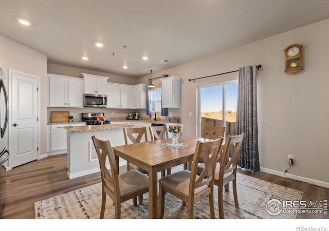 dining room with dark hardwood / wood-style floors and sink