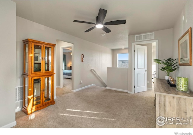 carpeted spare room with ceiling fan