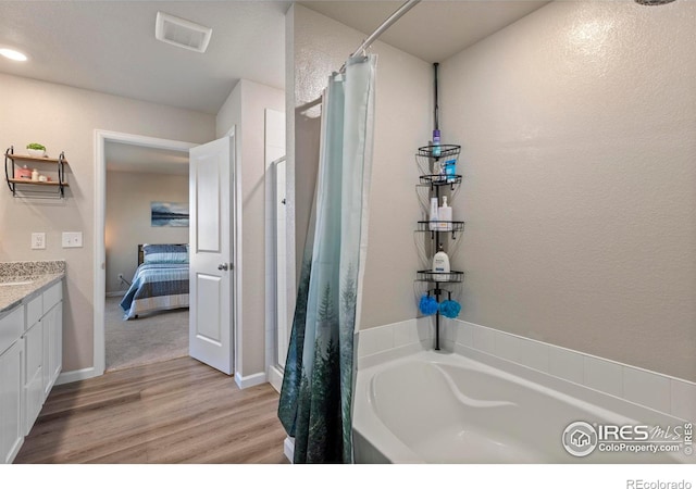 bathroom featuring hardwood / wood-style flooring, vanity, and independent shower and bath