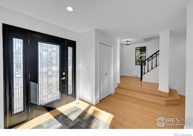 entrance foyer featuring visible vents, baseboards, stairway, recessed lighting, and wood finished floors