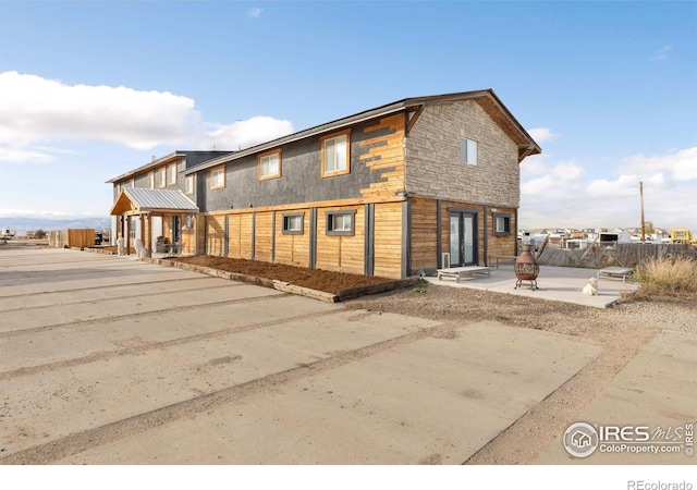 view of front of home with an outdoor fire pit and a patio area