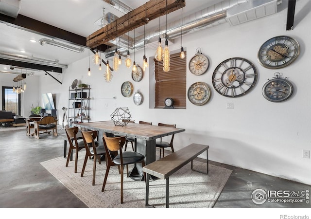 dining room featuring beamed ceiling and concrete flooring