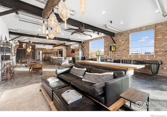 living room featuring brick wall, concrete floors, and beam ceiling