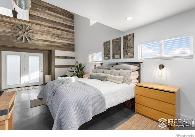 bedroom featuring a towering ceiling and wood walls