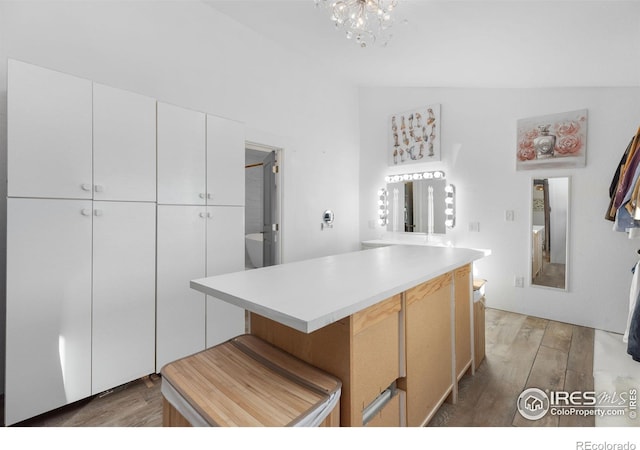 kitchen featuring a center island, an inviting chandelier, white cabinets, and dark hardwood / wood-style flooring