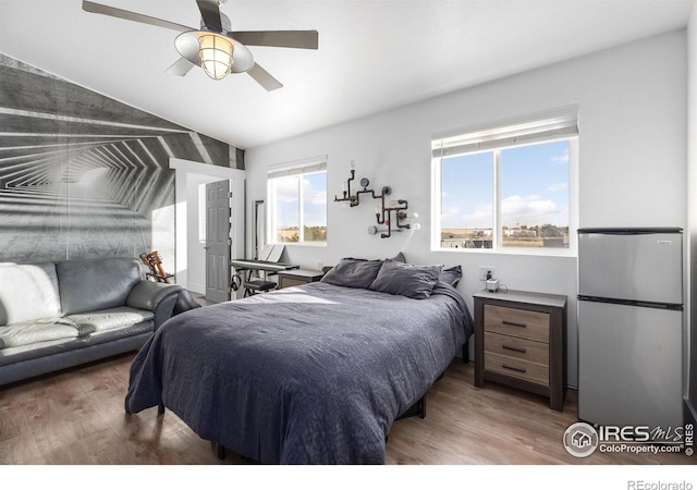 bedroom featuring hardwood / wood-style floors, stainless steel refrigerator, and ceiling fan