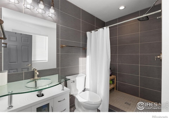 bathroom with tile walls, vanity, toilet, and a shower with shower curtain