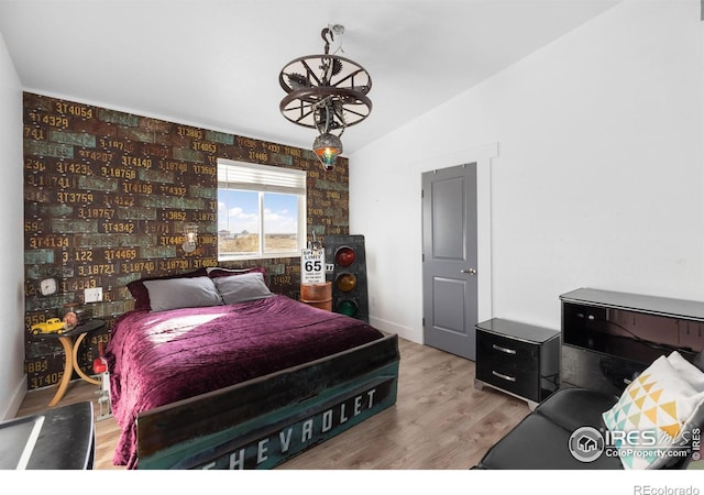 bedroom with lofted ceiling and light hardwood / wood-style floors