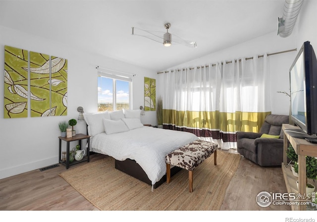 bedroom with lofted ceiling, hardwood / wood-style flooring, and ceiling fan