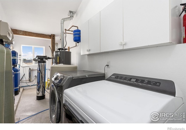 clothes washing area with cabinets, independent washer and dryer, and water heater