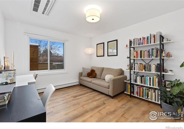 office area with a baseboard radiator and light wood-type flooring