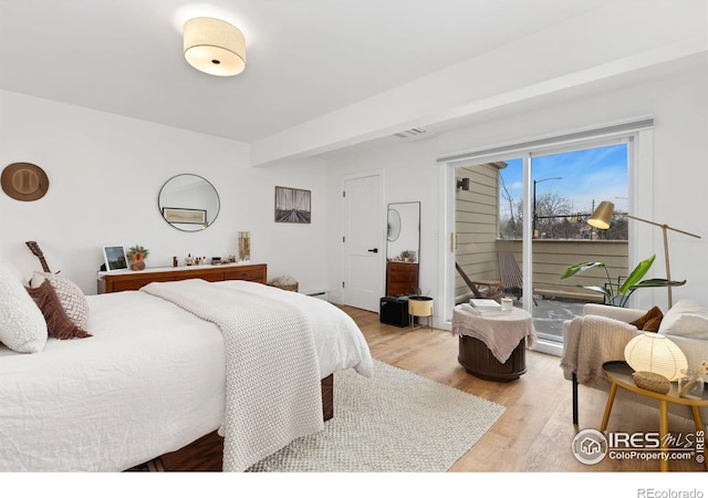 bedroom with beam ceiling, access to exterior, and light wood-type flooring