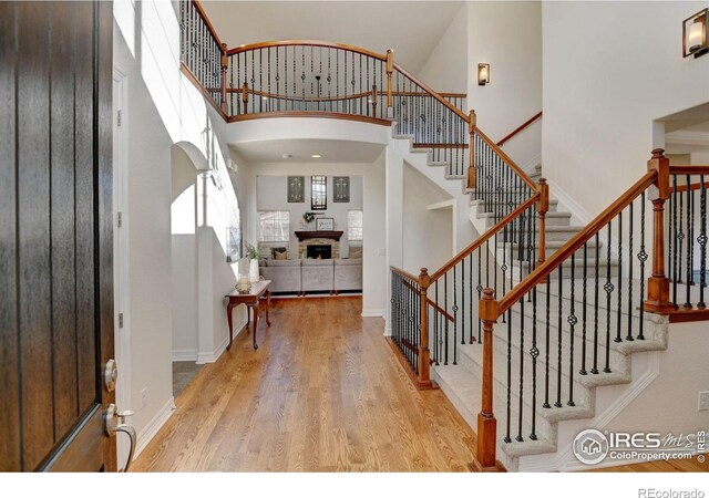 entrance foyer featuring a towering ceiling and light wood-type flooring